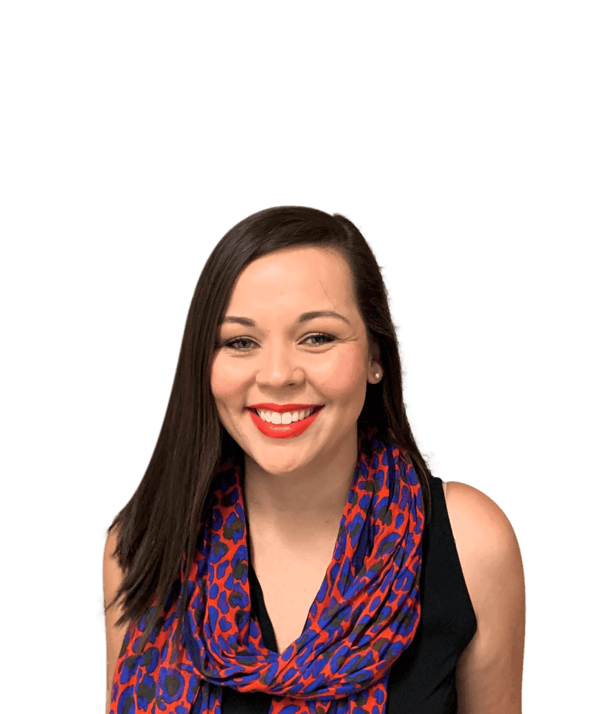 A woman smiles towards the camera with a blurred background, wearing a blue and red scarf.