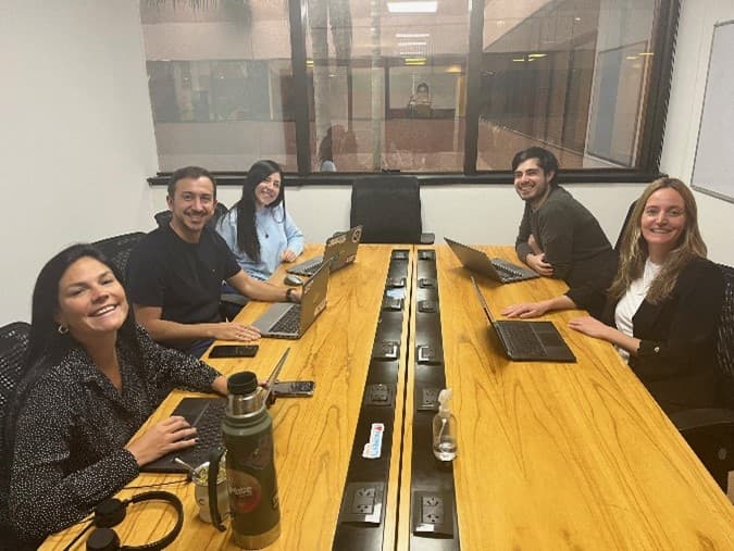 5 colleagues in an office room on laptops