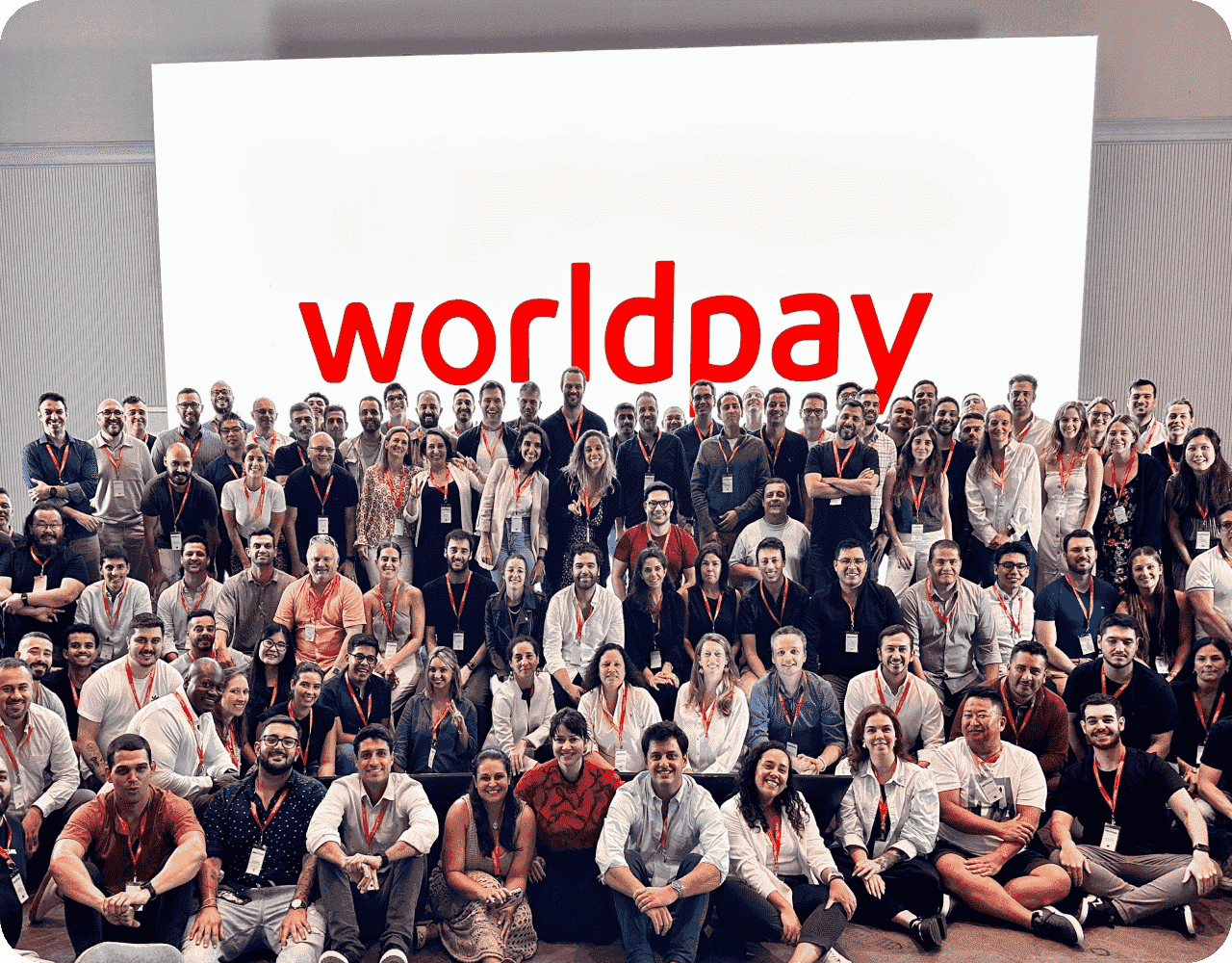 Big group of people in front of white and red sign