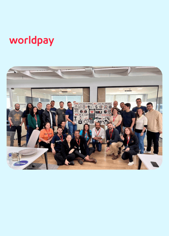 group of colleagues together with lego wall behind