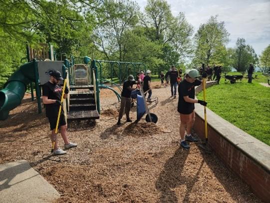 Worldpayers laying mulch in a playground