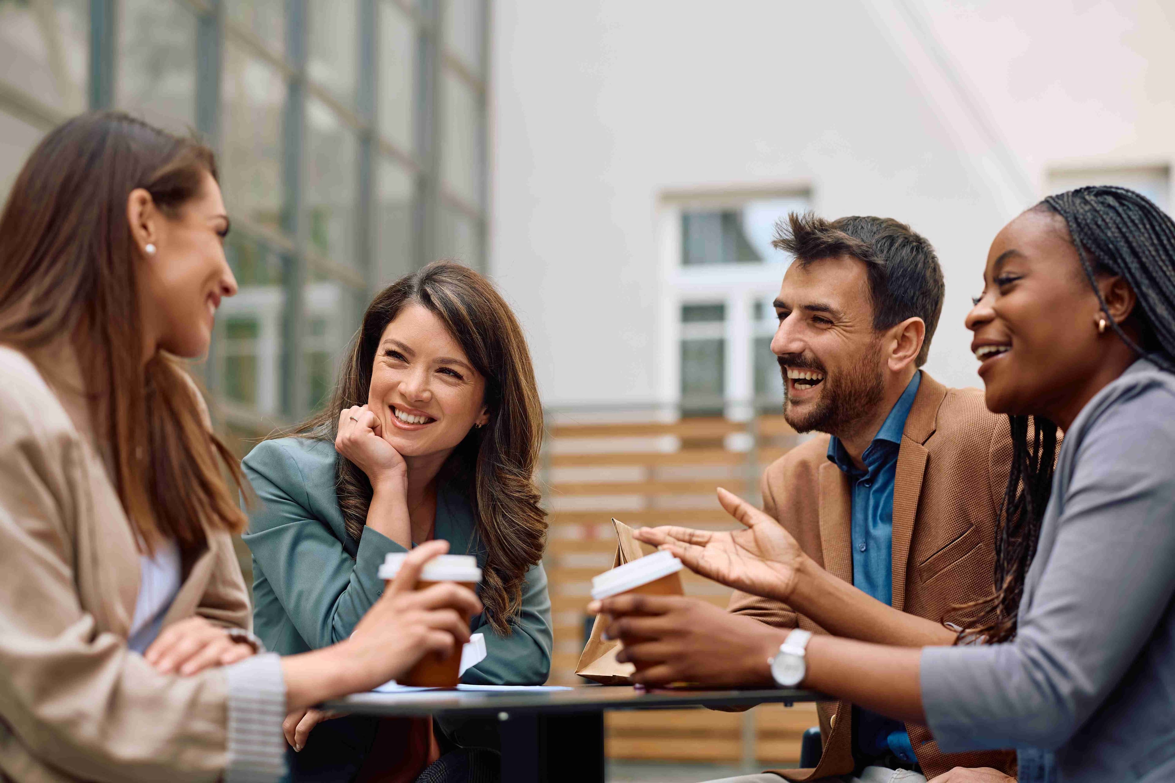 Diverse group of people standing infront of colourful sign at a conference